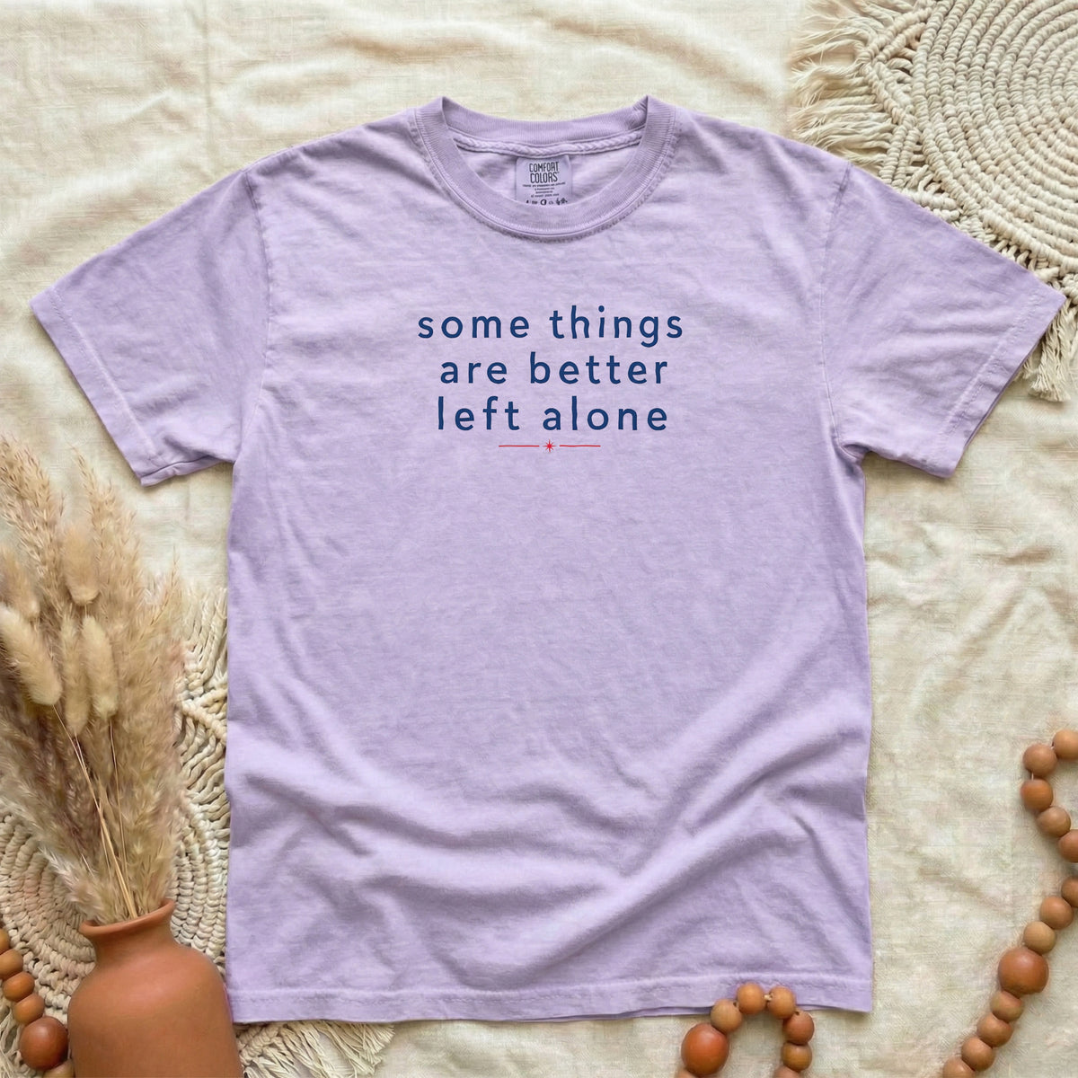 Orchid garment-dyed cotton tee printed with "Some Things Are Better Left Alone".