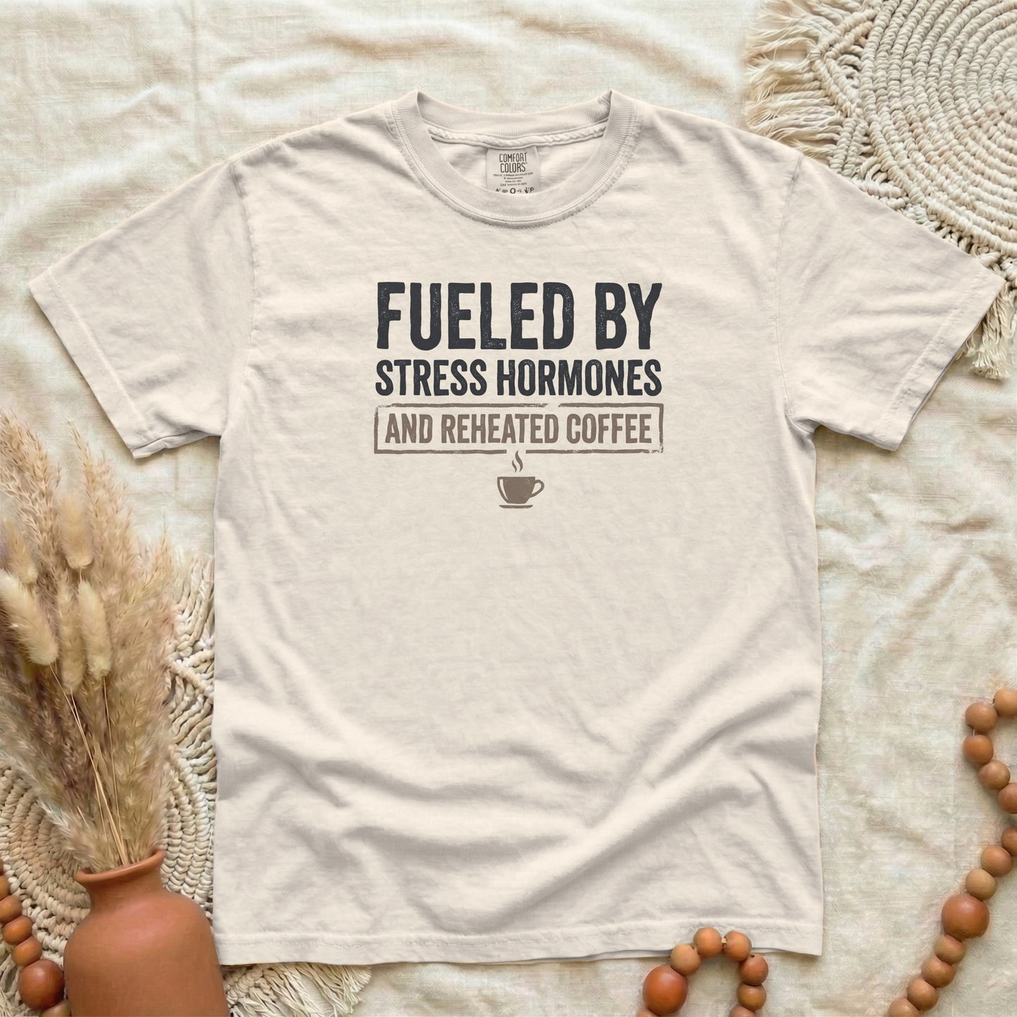 Ivory garment-dyed cotton tee printed with "Fueled By Stress Hormones And Reheated Coffee".