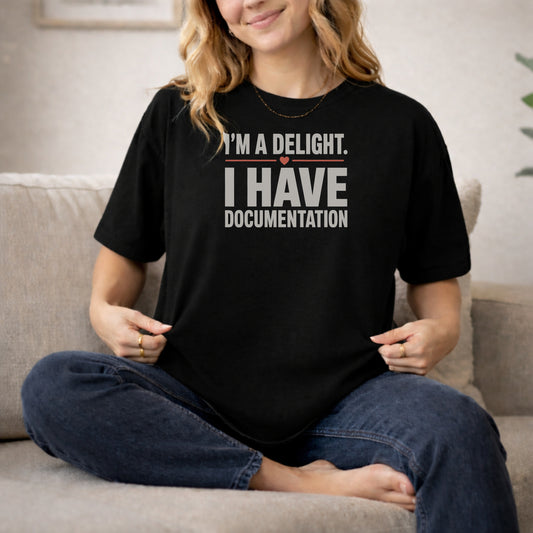 Black garment-dyed cotton tee printed with "I'm A Delight. I Have Documentation."