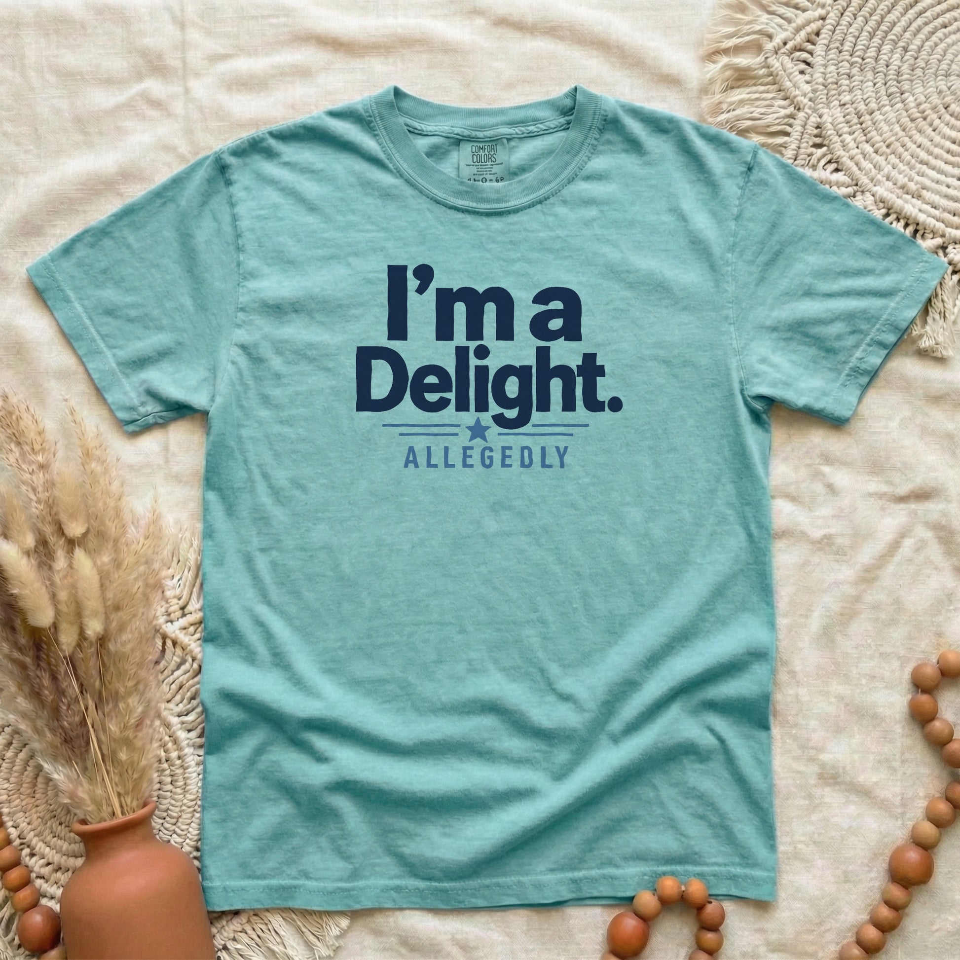 Chalky Mint garment-dyed cotton tee printed with "I'm A Delight, Allegedly".
