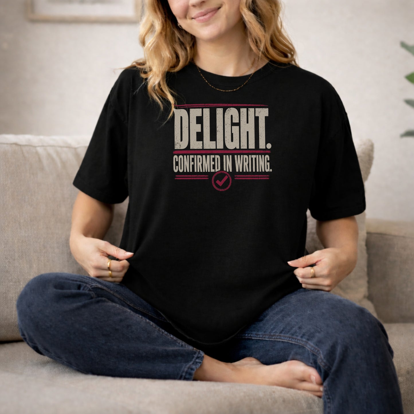 Black garment-dyed cotton tee printed with "Delight. Confirmed In Writing."