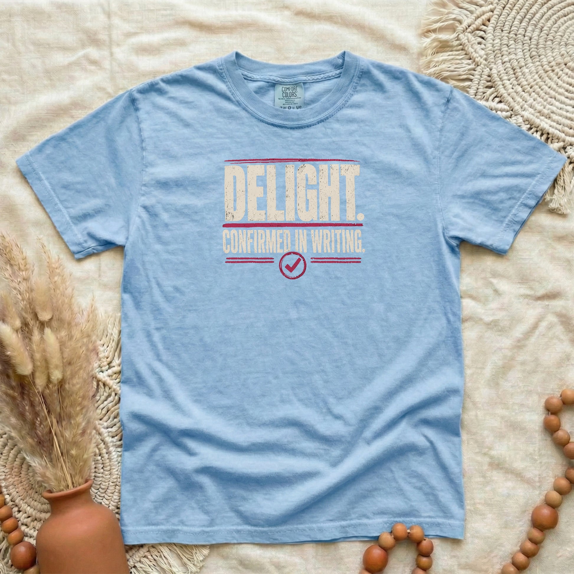 Washed Denim garment-dyed cotton tee printed with "Delight. Confirmed In Writing."