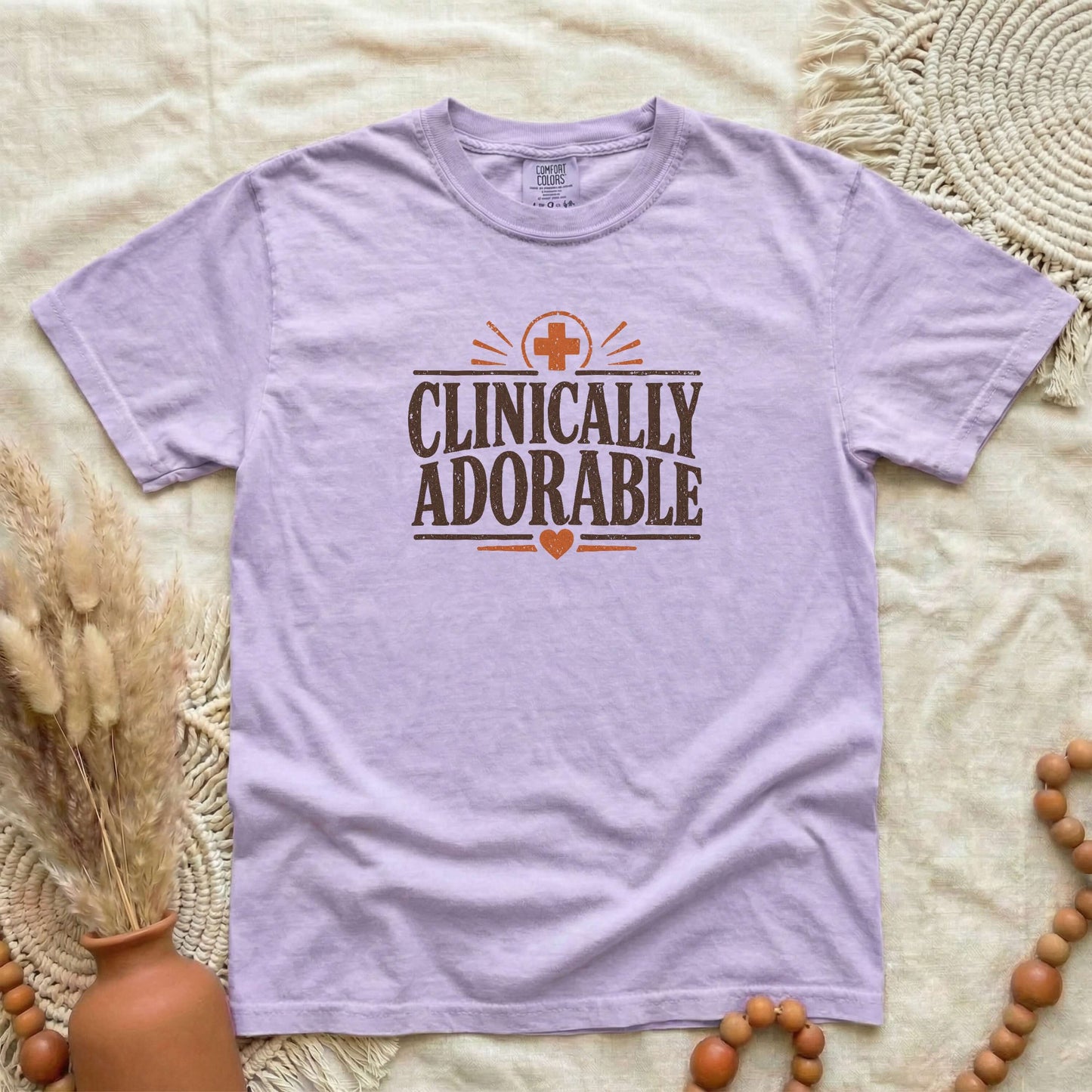 Orchid garment-dyed cotton tee printed with "Clinically Adorable".