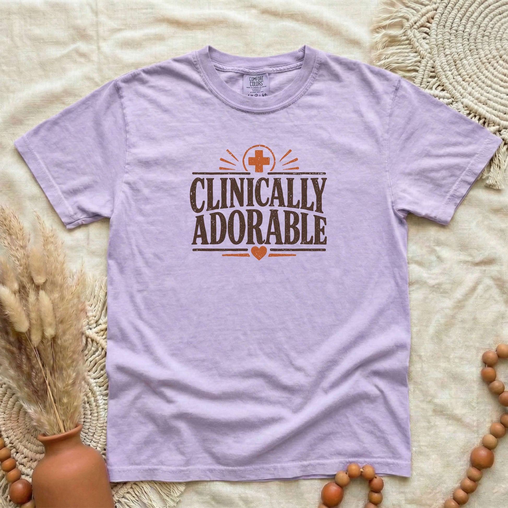 Orchid garment-dyed cotton tee printed with "Clinically Adorable".