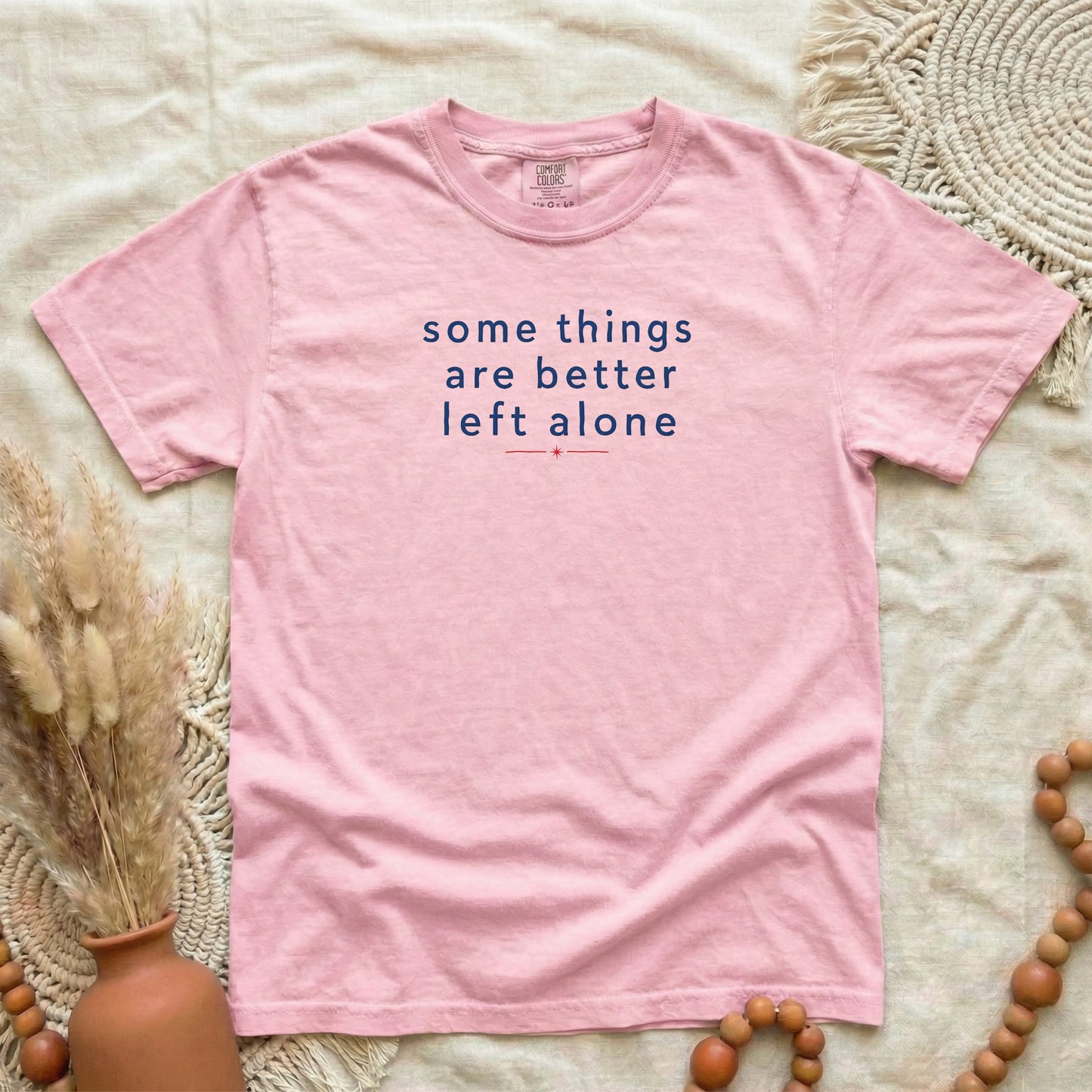 Blossom garment-dyed cotton tee printed with "Some Things Are Better Left Alone".