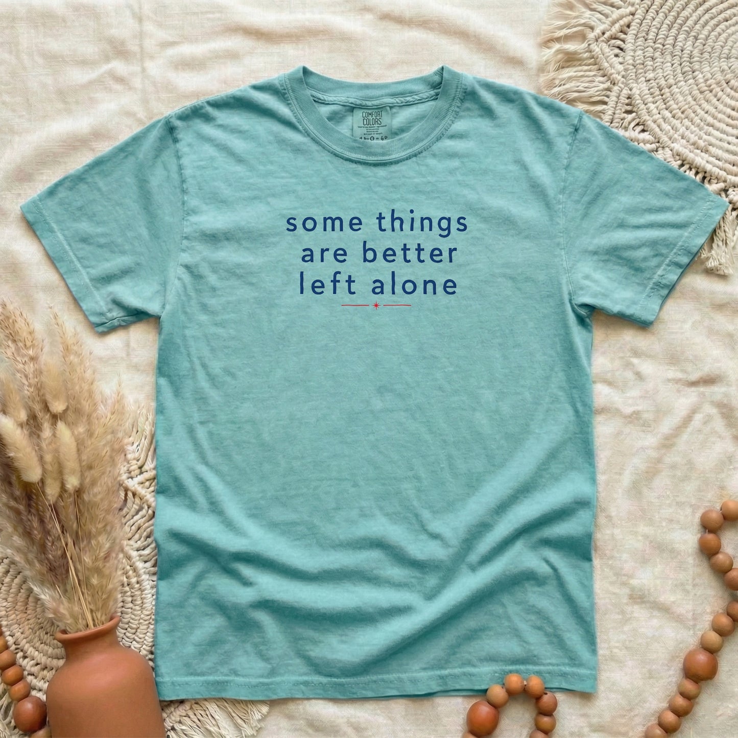 Chalky Mint garment-dyed cotton tee printed with "Some Things Are Better Left Alone".