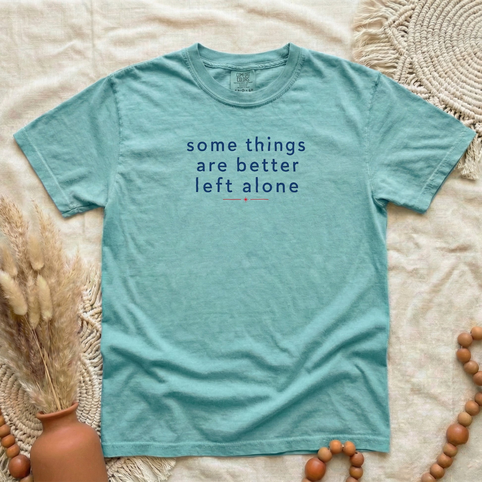 Chalky Mint garment-dyed cotton tee printed with "Some Things Are Better Left Alone".