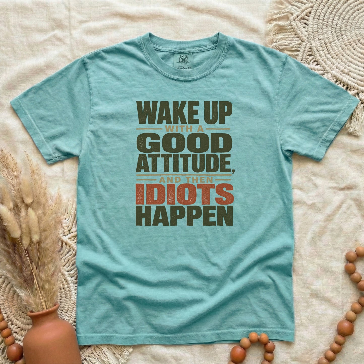 Chalky Mint garment-dyed cotton tee printed with "Wake Up With A Good Attitude, And Then Idiots Happen".