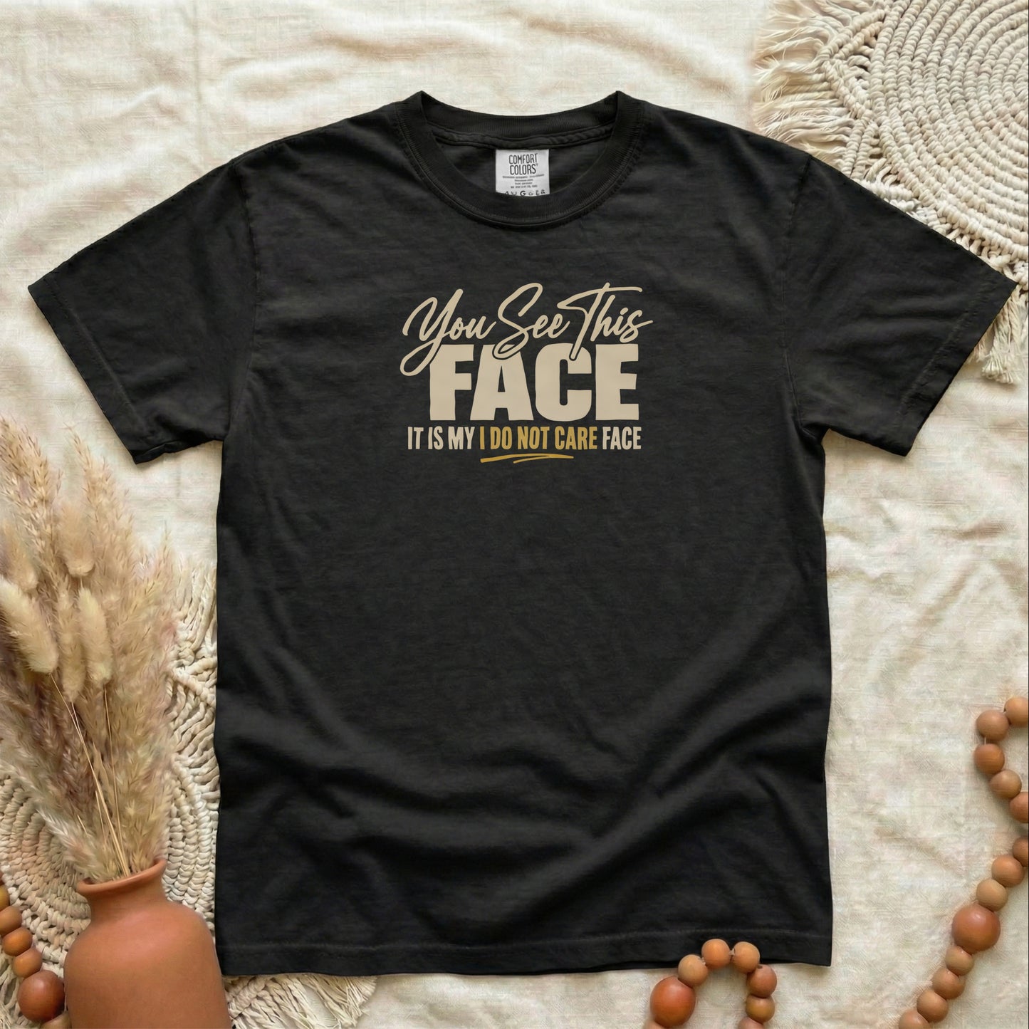 Black garment-dyed cotton tee printed with "You See This Face, It Is My I Do Not Care Face".