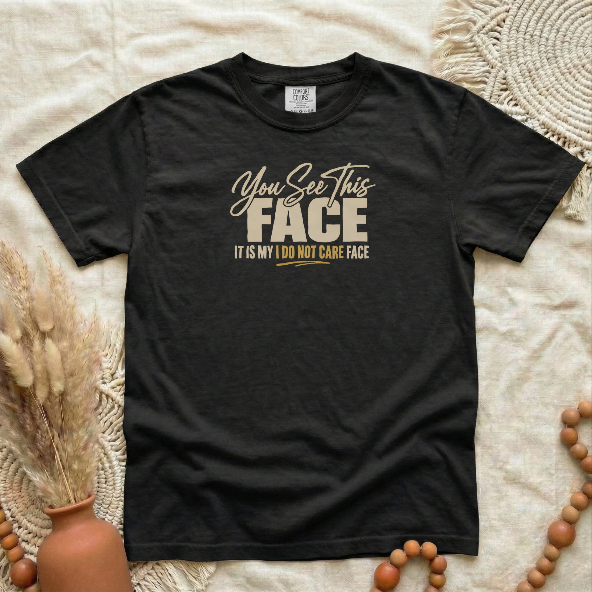 Black garment-dyed cotton tee printed with "You See This Face, It Is My I Do Not Care Face".