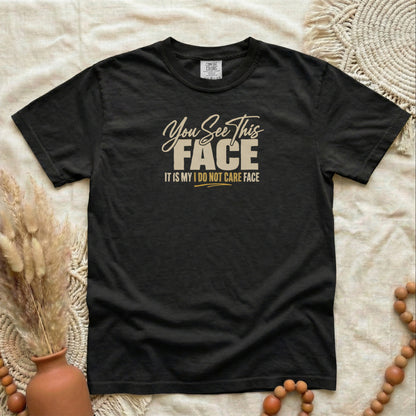 Black garment-dyed cotton tee printed with "You See This Face, It Is My I Do Not Care Face".