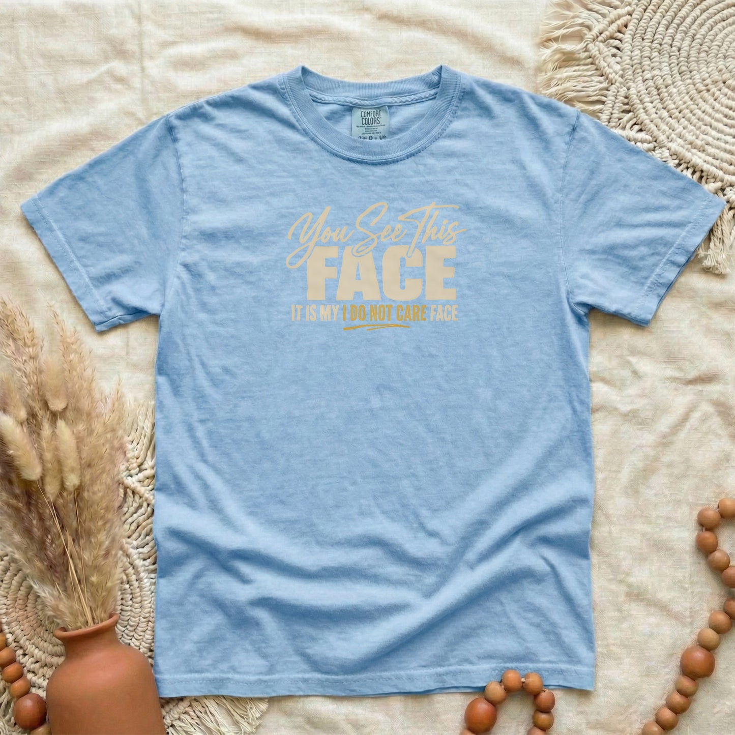 Washed Denim garment-dyed cotton tee printed with "You See This Face, It Is My I Do Not Care Face".