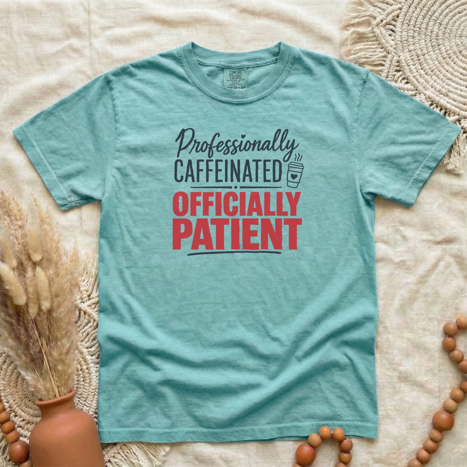 Chalky Mint garment-dyed cotton tee printed with "Professionally Caffeinated, Officially Patient".