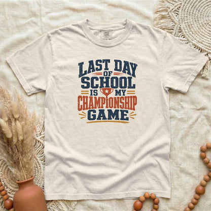Ivory garment-dyed cotton tee printed with "Last Day Of School Is My Championship Game".