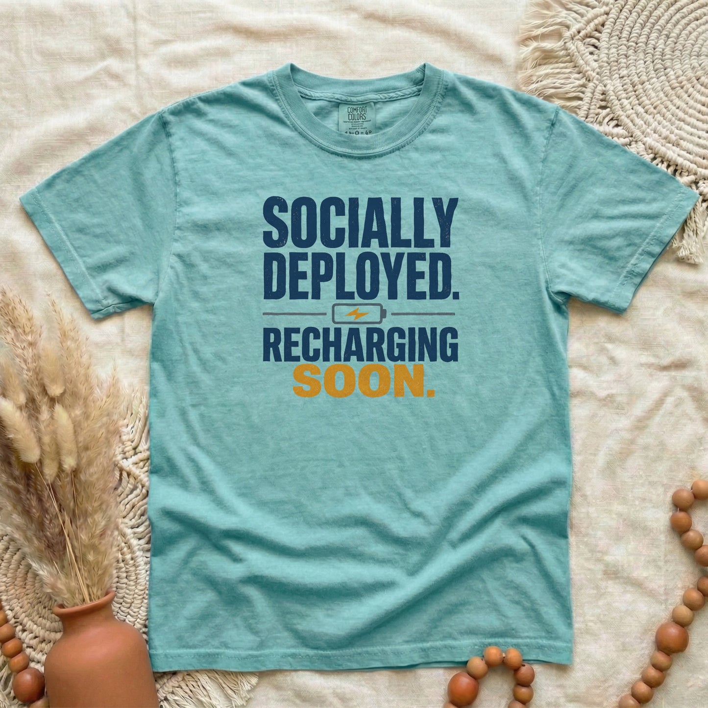 Chalky Mint garment-dyed cotton tee printed with "Socially Deployed. Recharging Soon."
