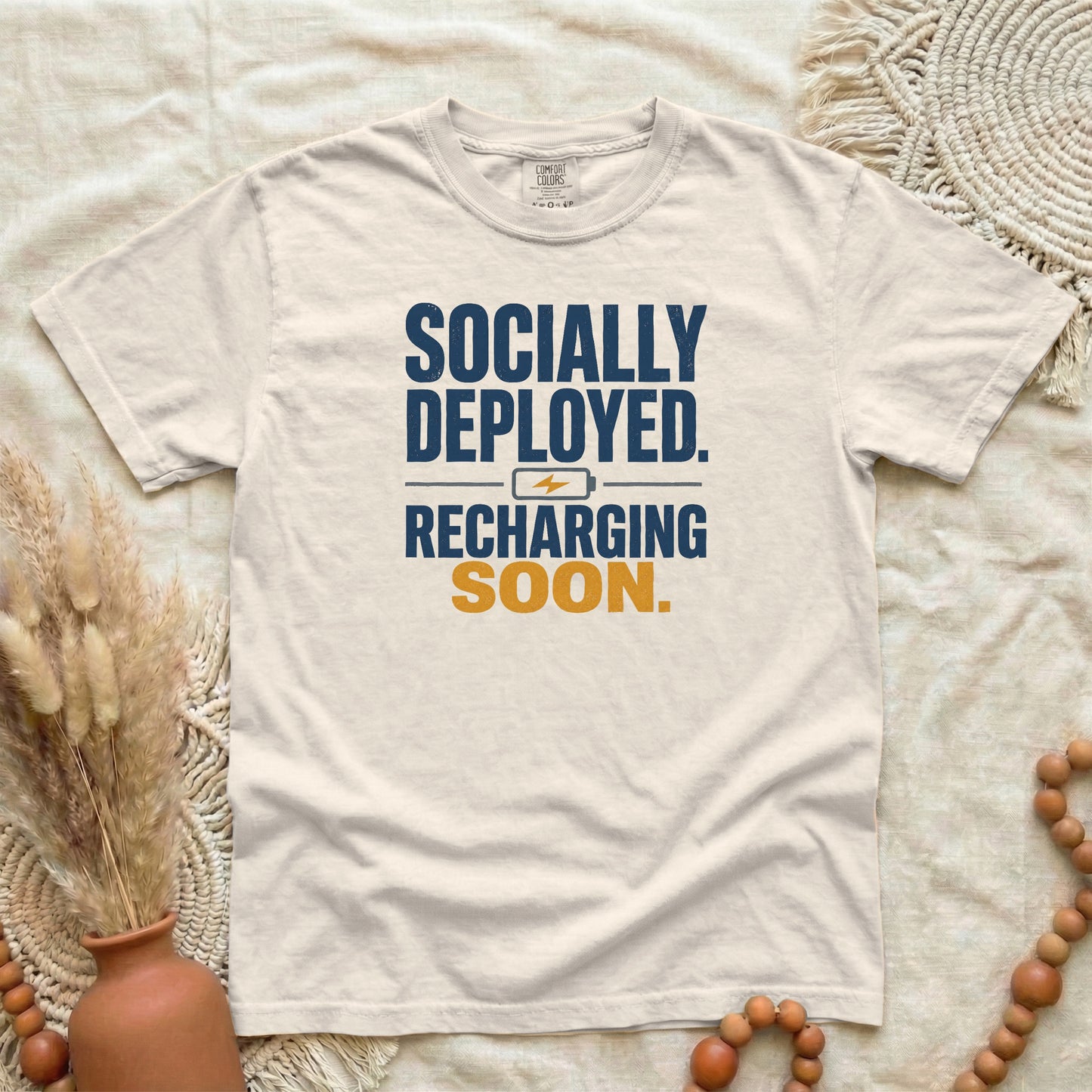 Ivory garment-dyed cotton tee printed with "Socially Deployed. Recharging Soon."