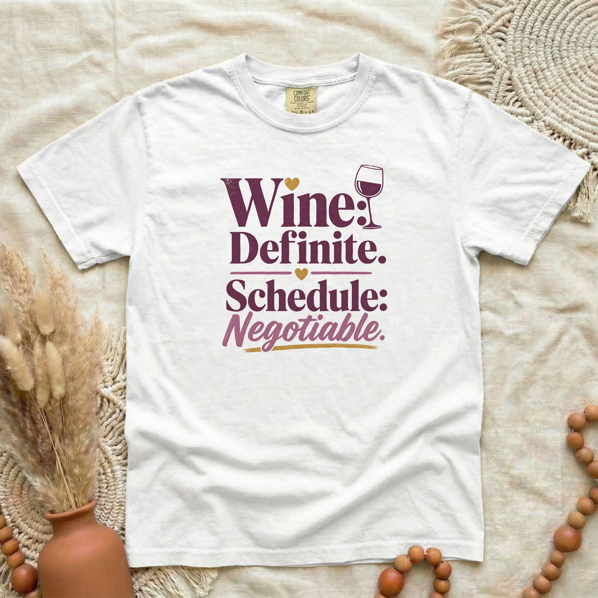 White garment-dyed cotton tee printed with "Wine: Definite. Schedule: Negotiable."