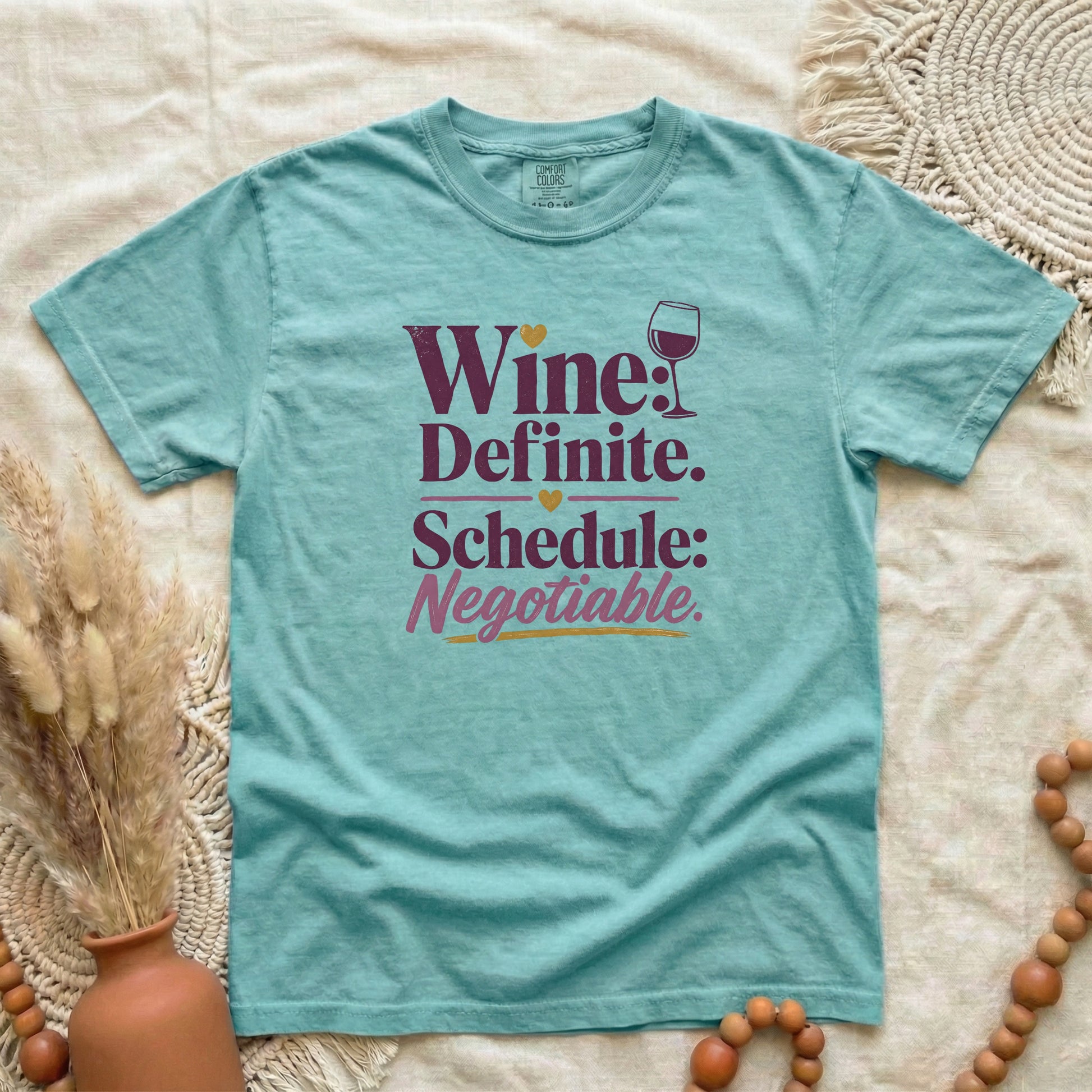 Chalky Mint garment-dyed cotton tee printed with "Wine: Definite. Schedule: Negotiable."